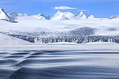 Landscape of Svalbard in Norway, also known as Spitsbergen. This territory stretches from latitude 75 to 80 degrees to the pack ice a few hundred kilometers from the North Pole. Melting ice, early global warming. Front of a glacier fracturing at the edge of a fjord.