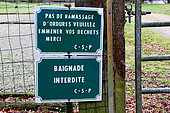 Sign "No garbage collection, please take your garbage away, Thank you" and "No swimming" on a fence in the countryside, Champagne, Sarthe, France