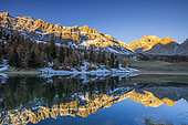 Lac des prés Soubeyrand or lac Miroir (2214 m), the sun illuminates the Crête des Veyrés (3000 m), and on the right the Pointe de la Saume (3043 m), Ceillac, Queyras Regional Natural Park, Hautes Alpes, France