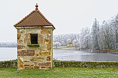 Small winter gatehouse on the pond causeway, opposite the old Tronçais forges in the heart of the forest - Allier. Built in 1788 - 1789 on the pond causeway, the Water Master's gatehouse housed the person who controlled and regulated the water inflows. This small building, unique in the region, stands on the overhang separating the two small feed canals (coursiers) of the former forges. The 18-hectare Etang de Tronçais is located in the heart of the Forêt de Tronçais. It was created in 1789 by Lorraine industrialist Nicolas Rambourg, who decided to establish his forges and furnaces here. The site provided him with the three elements essential to his business: iron ore, wood for heating, and water for mechanical power. Listed in the inventory of sites since February 1, 1934, it now belongs to the public domain. The Tronçais forest is considered to be one of the finest oak forests in Europe. It was awarded the Forêt d'Exception label in 2018. This label is a guarantee of excellence. France