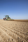Farmer using a rotary harrow to prepare loamy, chalky soil prior to spring sowing in the Brie region of France.