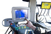Farmer controlling his display, antenna or receiver located on a tractor receiving signals from satellites and transmitting them to the guidance device. GPS. guidance system for precision agriculture. Brie, France