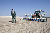 Farmer monitoring seeding quality and depth. Sowing beet or sunflowers with a precision drill in limestone loam in the Brie region, France.