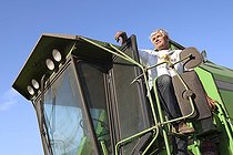 Portrait of a 60-year-old farmer looking out of the cab door of his deutz fahr harvester, France