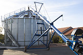Corn grain drying plant with galvanized silos and mixing screws. The boilers are fuelled by wood chips, oil or gas, France