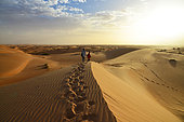 Tourists walking in the dunes of the Adrar desert near Chinguetti. Ancient ksour of Ouadane, Chinguetti, Tichitt and Oualata. Adrar. Mauritania
