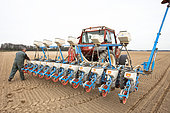 Sowing beet with a 12-row precision seeder on loamy soil, Farmer controlling the filling of the seed tanks, Marne, France