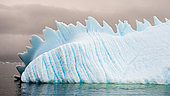 Bluish iceberg in the shape of a dinosaur's back in Hidden Bay, Antarctic Peninsula
