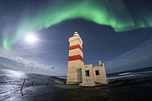 Aurora borealis and old Garður lighthouse, Iceland.