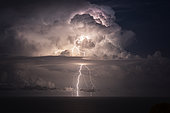 Thunderstorm in the Mediterranean, opposite San Remo, Liguria, Italy. Extra-cloudy lightning during a vigorous thunderstorm between Corsica and the mainland.