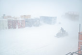 Technician on a snowmobile/skidoo travelling between the station and a line of containers in thick fog. Quite a strong white-out. During such an event, staff outings are reduced to a strict minimum as the risk of becoming disorientated is at its highest, with visibility reduced to just a few metres. Only the technicians managing the emergency can travel by snowmobile. Concordia Antarctic Research Station, Dome C plateau, East Antarctica.