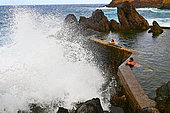 Bathers in the natural pools by the sea. Porto Moniz. Madeira island. Portugal.