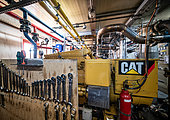 Inside the power plant, a view of an electric generator. A generator consists of a diesel engine, identical to that of a truck, which drives a generator (a sort of very large dynamo) in rotation. This unit produces enough electricity for the whole resort, and the heat released is used to heat the two towers and some workshops, as well as to melt snow to produce fresh water. There are three generators: they operate in turn, leaving enough time for technicians to carry out the necessary maintenance. Concordia Antarctic Research Station, Dome C plateau, East Antarctica.