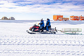 Two scientists use a snowmobile to get around the station. Concordia Antarctic Research Station, Dome C plateau, East Antarctica.
