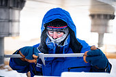 A scientist makes a series of measurements on a piece of snow to determine its structure, hardness, etc. near the feet of the Concordia station. Concordia Antarctic Research Station, Dome C plateau, East Antarctica.