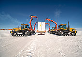 4 tractors are used to unload a container from its Raid sled. Concordia Antarctic Research Station, Dome C plateau, East Antarctica.
