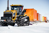 A Raid tractor and its convoy of containers on sledges. Concordia Antarctic Research Station, Dome C plateau, East Antarctica.