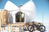An electric bicycle parked in front of the ASTEP telescope dome. Concordia Antarctic Research Station, Dome C plateau, East Antarctica.