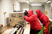 Two scientists cut and pack ice cores. They work for the German polar institute, AWI. Concordia Antarctic Research Station, Dome C plateau, East Antarctica.
