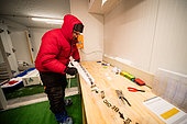 Two scientists cut and pack ice cores. Here, half a core is wrapped in a plastic container. Concordia Antarctic Research Station, Dome C plateau, East Antarctica.