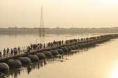 Kumbh Mela 2025: The Sacred Goes Viral. Crossing the Sacred Waters. Pilgrims on the Floating Bridges of the Kumbh Mela. As millions of pilgrims arrive at the Maha Kumbh Mela, the floating bridges serve as vital passages over the holy Ganges River. Walking across these makeshift structures, pilgrims are not just crossing water, they are crossing into a deeper spiritual realm. The path is lined with devotion, as each step brings them closer to purification and peace. These bridges, built to withstand the immense flow of people, represent both the physical and spiritual journeys that define the Kumbh Mela, where faith and resilience merge on the sacred waters.