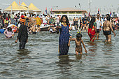 Kumbh Mela 2025: The Sacred Goes Viral. A Mother's Selfie with Her Child in the Sacred Waters. A Woman and Her Child Attempting a Selfie at the Kumbh Mela. In the sacred waters of the Ganges, a woman tries to capture a moment with her child, attempting a selfie while surrounded by the spiritual energy of the Kumbh Mela. Her child, however, seems more focused on playing in the water, eager to engage in the purification ritual rather than pose for the camera. The scene beautifully contrasts the mother's desire to preserve the memory of this sacred experience and the child's innocent connection to the ritual of bathing. This moment captures the joyful spontaneity of a mother-child bond, while also reflecting the blend of devotion, modernity, and youthful curiosity that defines the Kumbh Mela.