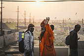 Kumbh Mela 2025: The Sacred Goes Viral. Sadhu Acknowledging the Photographer at the Kumbh Mela. At the Kumbh Mela, a sadhu, with his unique appearance and serene expression, acknowledges the photographer while standing by the river. Dressed in traditional attire with painted face, his presence is a symbol of devotion and asceticism. As the sacred river flows behind him, the sadhu becomes an integral part of the vibrant cultural and spiritual tapestry of the Kumbh Mela. This interaction between the photographer and the sadhu captures a moment of connection, where both the sacred and the mundane meet, highlighting the dynamic exchange that defines the festival.