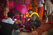 Kumbh Mela 2025: The Sacred Goes Viral. A Young Sadhu in the Heart of the Kumbh Mela. A Child Sadhu at the Kumbh Mela: The Innocence of Devotion. In a dimly lit tent filled with spiritual energy, a young sadhu sits serenely, raising his hand in blessing. Dressed in bright orange, his innocent face is adorned with necklaces and surrounded by a sense of purity and devotion. A group of adult devotees stands in the background, with one woman holding offerings while others look on. The tent glows warmly with decorative lights, creating a contrast between the child’s spiritual purity and the bustling activity of the Kumbh Mela around him. This scene encapsulates the timeless nature of devotion, where even the youngest participants contribute to the sacred atmosphere of the event.