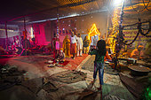 Kumbh Mela 2025: The Sacred Goes Viral. A Child Captures a Sadhu's Presence at the Kumbh Mela. The Innocence of Youth: A Pilgrim Child Photographs a Sadhu. Inside a vibrantly decorated tent at the Kumbh Mela, a young child, wearing a green shirt, captures a photograph of a sadhu, whose child-like innocence and spiritual presence contrast beautifully. The child stands in front of the Sadhu, a young devotee, and as she raises her phone, the scene encapsulates the merging of the sacred and modern moments. The warm lights illuminate the area, emphasizing how even the youngest pilgrims participate in preserving these spiritual experiences through the lens of technology. The scene highlights the innocence and wonder that accompany the sacred practices of the Kumbh Mela.