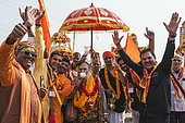 Kumbh Mela 2025: The Sacred Goes Viral. Festive Spirit at the Kumbh Mela: Pilgrims and Sadhus Celebratin. A Group of Devotees and Sadhus Celebrate with Joy at the Kumbh Mela Procession. During the vibrant Kumbh Mela procession, pilgrims and sadhus come together in joyous celebration. Posing for photos, they display their enthusiasm, with some holding ceremonial umbrellas and wearing marigold garlands. The energy and camaraderie shared by everyone—whether a devotee, a sadhu, or a visitor—create a powerful sense of unity amidst the sacred rituals of the event.
