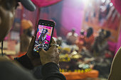 Kumbh Mela 2025: The Sacred Goes Viral. Capturing Sacred Moments. In the midst of the spiritual fervor at the Maha Kumbh Mela, the sacred tents of the Naga Sadhus become not only a symbol of asceticism but also a modern-day attraction. Pilgrims, with their smartphones in hand, pause to capture the moment, blending ancient spirituality with contemporary expression. As the Naga Sadhus remain focused on their spiritual journey, the pilgrims share their experiences in real time, allowing the sacred event to transcend physical boundaries. This fusion of devotion and digital documentation reflects the evolving nature of pilgrimage, where faith and modern technology coexist.