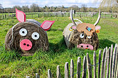Straw-bale pig and cow in a field at l'arche de la nature, Le Mans, Sarthe, France