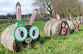 Straw-bale rabbit, pig and cow in a field at l'arche de la nature, Le Mans, Sarthe, France