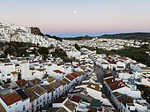 The White Town of Olvera with full moon at dusk. Aerial view. Drone shot. Cádiz province, Andalusia, Spain.