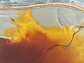 Waste pond in the mineral-rich area of the Rio Tinto mines. The colour is caused by oxidised iron minerals. Aerial view. Drone shot. Huelva province, Andalusia, Spain.