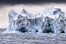 Iceberg and large fragments of drifting ice, here iceberg floating in front of the Antarctic Peninsula, climate melting global warming. Marguerite Bay, George VI Channel. Expedition below the South Polar Circle in Antarctica