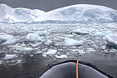 Iceberg and large fragments of drifting ice, here iceberg floating in front of the Antarctic Peninsula in front of a zodiac on the Southern Sea, climate melting global warming. Marguerite Bay, George VI Channel. Expedition below the South Polar Circle in Antarctica