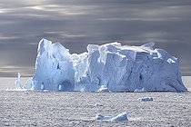 Iceberg and large fragments of drifting ice, here iceberg floating in front of the Antarctic Peninsula, climate melting global warming. Marguerite Bay, George VI Channel. Expedition below the South Polar Circle in Antarctica