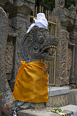 Dressed statue. Gitgit waterfall. Island of Bali. Indonesia.