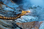 Illuminated pontoon overlooking the Jigokudani geothermal site, Noboribetsu, Hokkaido Island, Japan. The geothermal area known as "Jigokudani", the valley of hell, is also accessible by night. The illuminated pontoon forms a kind of garland across the apocalyptic landscape.