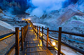 Illuminated pontoon overlooking the Jigokudani geothermal site, Noboribetsu, Hokkaido Island, Japan. The geothermal area known as "Jigokudani", the valley of hell, is also accessible by night. The illuminated pontoon forms a kind of garland across the apocalyptic landscape.