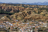 White village on the edge of badlands in the Granada Geopark, Spain. Beas de Guadix. Alluvial deposits of late Miocene conglomerates and clays, eroded into spectacular badlands. Andalusia