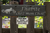 Signs on a fence, "well-behaved cat", "I live with my cat", humor, garden, house, Kaysersberg, Haut Rhin, France