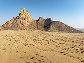 The isolated Spitzkoppe mountain (1728 m) majestically rises above the surrounding desert plains. Aerial view. Drone shot. Damaraland, Namibia.