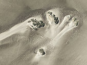 Small sand heaps form around the sparse vegetation in the Namib Desert. Aerial view. Drone shot. Skeleton Coast National Park, Namibia.