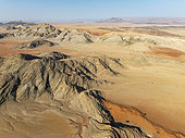 Arid plains, sand dunes and bare mountain ridges in the Tsondab Valley in the Namib Desert. Aerial view. Drone shot. Namibia.