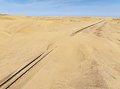 Rails covered with sand in the southern Namib Desert. Aerial view. Drone shot. Namibia.