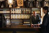 Barman prepares Spritz aperitives in the Nardini bar. The bar has hardly changed since it opened in 1779. Bassano del Grappa, Veneto, Italy