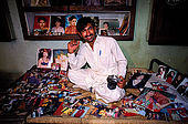 Pakistan - Hijra, les demi-femmes du Pakistan - Mohammed, photographe ne travaille qu'avec les Hijra qui sont d'excellent client. Ici chez lui avec ses tirages