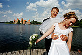 Trakai, Lithuania: just married posing in front of the insular castle (Traku pilis)